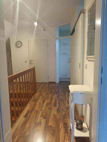 a room with a wooden floor and a white table at Apartment am Vechtesee in Schüttorf