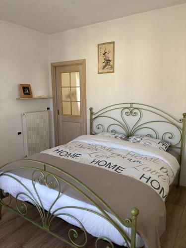 a bedroom with a bed with a sign that reads love home home at Casa Marta in Lisignago