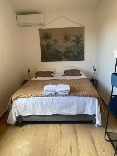 a bedroom with a large bed with two towels on it at O coeur de l'ouest Bungalow Maloya in Le Bois de Nèfles