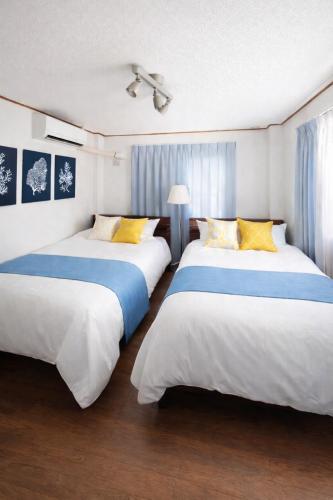 two beds in a room with blue and white at Ocean Flat 江ノ島鵠沼海岸 in Fujisawa