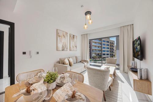 a living room with a table and chairs and a couch at Chic 2BR Haven in Prime Location in Gardenia Living in Dubai