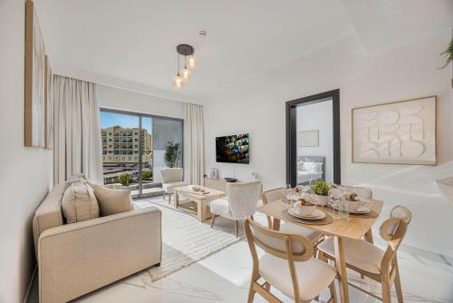 a living room with a table and a couch at Chic 2BR Haven in Prime Location in Gardenia Living in Dubai