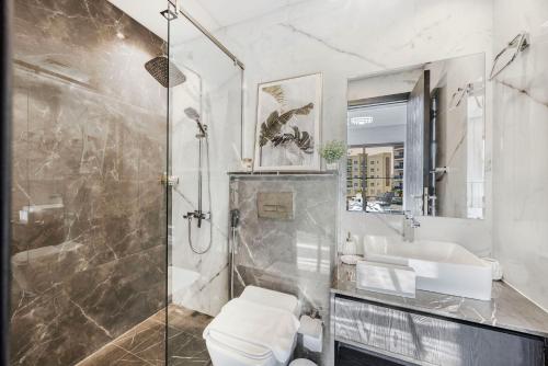 a bathroom with a shower and a toilet and a sink at Chic 2BR Haven in Prime Location in Gardenia Living in Dubai