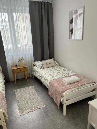 a small bedroom with a bed and a table at Apartament Szpitalna Możliwość wystawiania Faktur, WI-FI in Suwałki