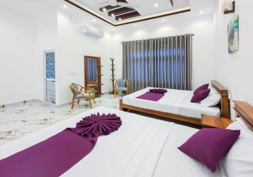 two beds in a room with purple pillows at Omar Villa in Bentota