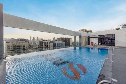 a large swimming pool on the roof of a building at Chic 2BR Haven in Prime Location in Gardenia Living in Dubai