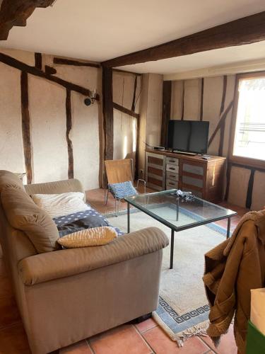 a living room with a couch and a glass table at Maison de caractère in Les Bordes-sur-Arize