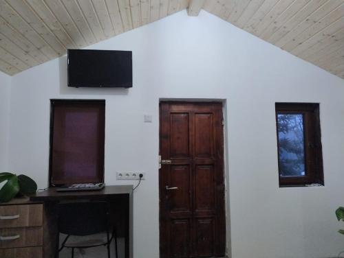 a room with a door and a desk with a computer at Casuta din Livada 3 in Drăganu-Olteni
