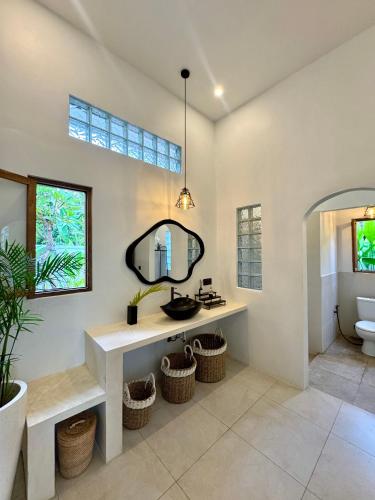 a bathroom with a sink and a mirror at Casa De Made - Villas in Jembrana
