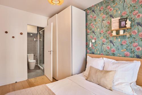 a bedroom with a bed with a floral wallpaper at Residence Boulogne Centre le passage by Studio prestige in Boulogne-Billancourt