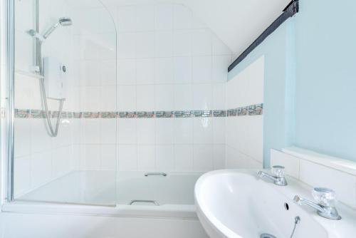 a white bathroom with a shower and a sink at 2 Bed in Wangford oc-8hsw in Wangford