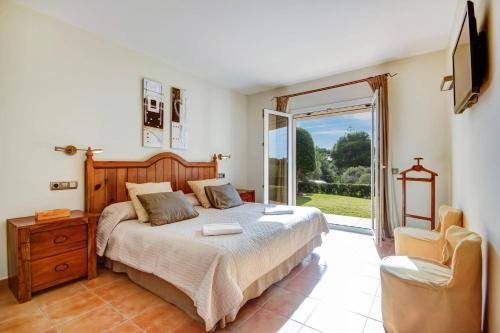 a bedroom with a bed and a sliding glass door at Villa Tama by Villa Plus in Sant Lluis