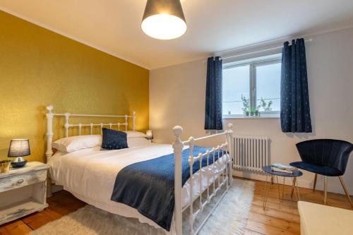 a bedroom with a bed and a chair and a window at 3 Bed in Kessingland oc-b27635 in Kessingland