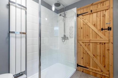a bathroom with a shower and a wooden door at 3 Bed in Kessingland oc-b27635 in Kessingland