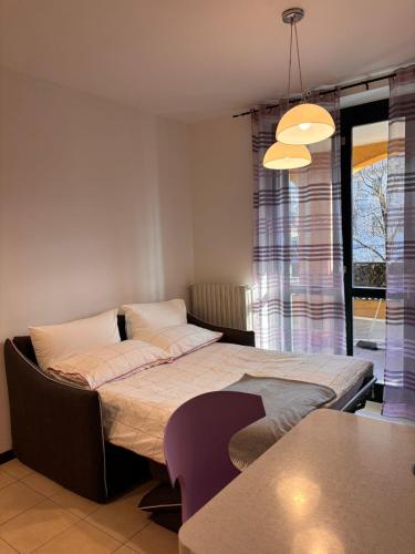 a bedroom with a bed with a table and a window at Casa San Martino 21 in Uboldo