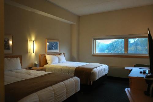 a hotel room with two beds and a window at Prince Conference Center & Hotel in Grand Rapids