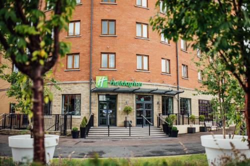 a large red brick building with a store at Holiday Inn Belfast by IHG in Belfast