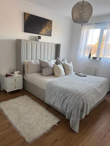 a bedroom with a white bed with a white rug at 2 Bed apartment- Laindon in Great Burstead