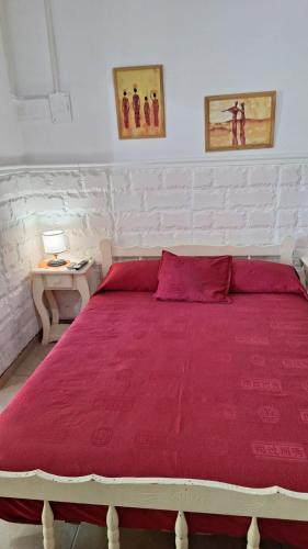 a bedroom with a large bed with red sheets at MONOAMBIENTE Flores del Cielo in Federación