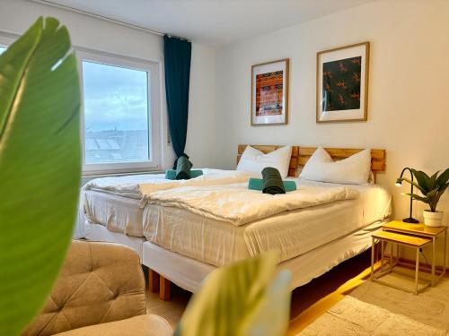 two beds in a room with a large window at Townhaus Mariaroth in Dieblich