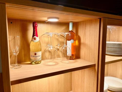 a cabinet with wine bottles and glasses on it at Townhaus Mariaroth in Dieblich