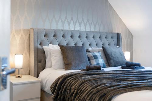 a bedroom with a large bed with a blue headboard at The Clydesider in Glasgow