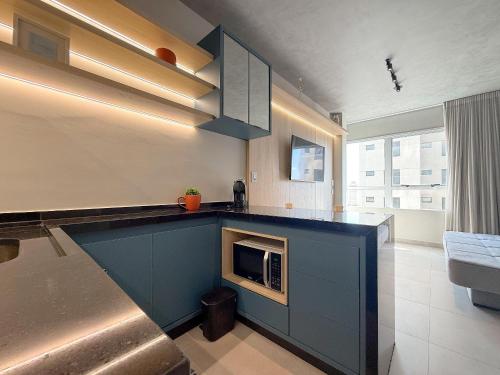 a kitchen with a blue counter with a microwave at Condomínio Residencial Hype 017 - São José do Rio Preto in Sao Jose do Rio Preto
