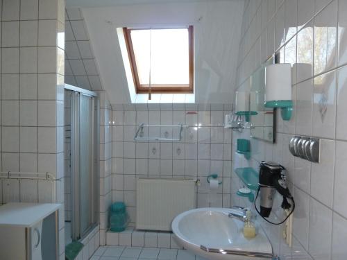 a white bathroom with a sink and a window at Ferienhof Gruber in Wesseloh