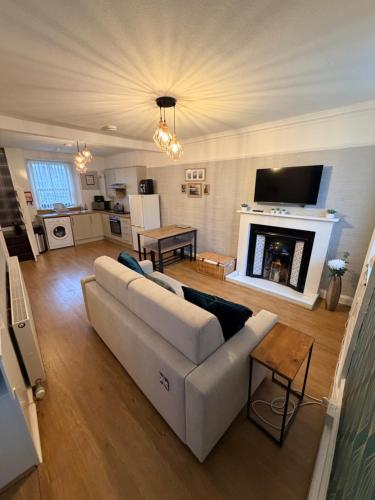 a living room with a white couch and a fireplace at Harris Apartment in Montrose