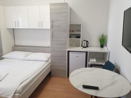 a small bedroom with a bed and a table at Soba brez balkona in Stara Novalja
