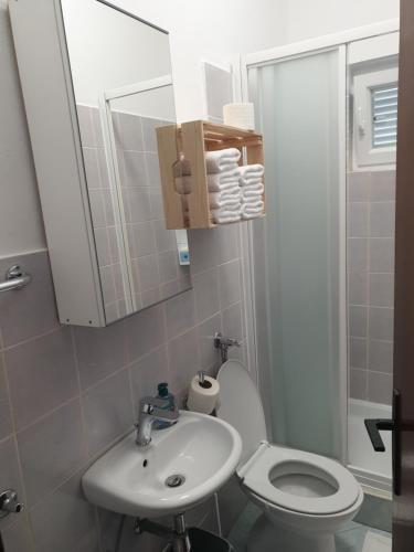 a bathroom with a white toilet and a sink at Soba brez balkona in Stara Novalja