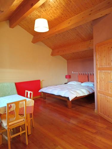 a bedroom with two beds and a table and chairs at Noyers du Soleil, Chambre d'hôte avec petit déjeuner à proximité de Gap in La Bâtie-Vieille