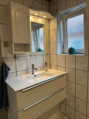 a bathroom with a sink and a mirror at Hyggehuset in Tønder