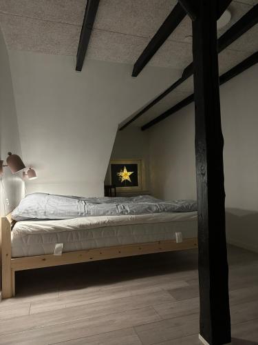 a bedroom with a bed with a wooden frame at Hyggehuset in Tønder