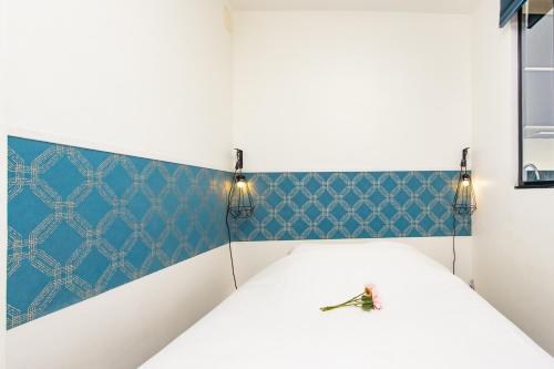 a bed in a room with blue wallpaper at Vue mer port de garavan in Menton