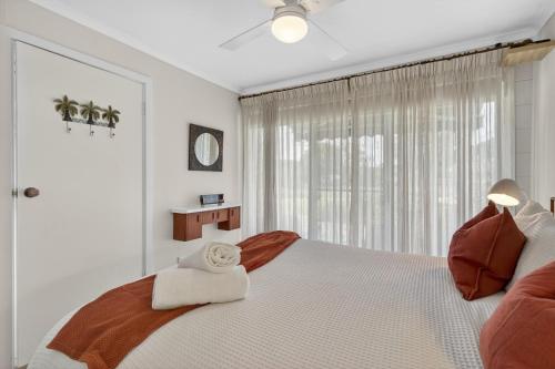 a white bedroom with a large bed and a window at Sixty at Yellow Doors in Goolwa South