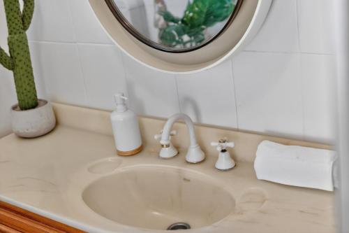 a bathroom sink with a round mirror above it at Sixty at Yellow Doors in Goolwa South
