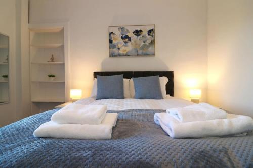 a bedroom with a bed with towels on it at Modern 2 Bedroom Cottage Flat in Stenhousemuir
