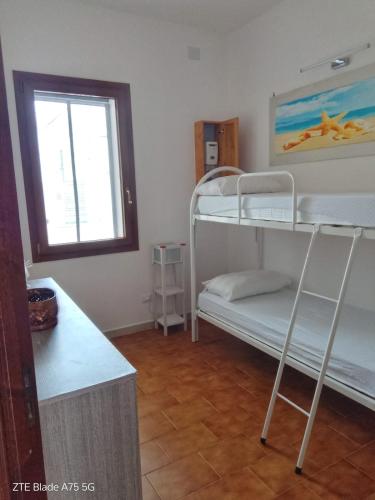 a room with two bunk beds and a window at AFRODITE in Porto Cesareo