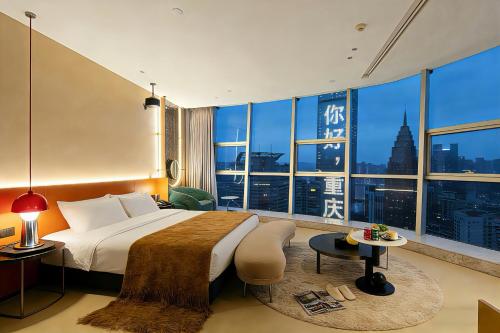a hotel room with a bed and a large window at Chongqing IBESHO HOTEL in Chongqing