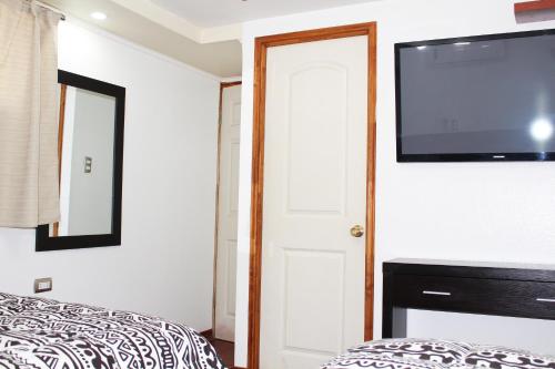 a bedroom with a flat screen tv on the wall at Residencial Victoria Said in Linares