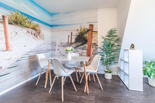 a dining room with a beach mural on the wall at Ferienwohnung Tina OG in Boltenhagen