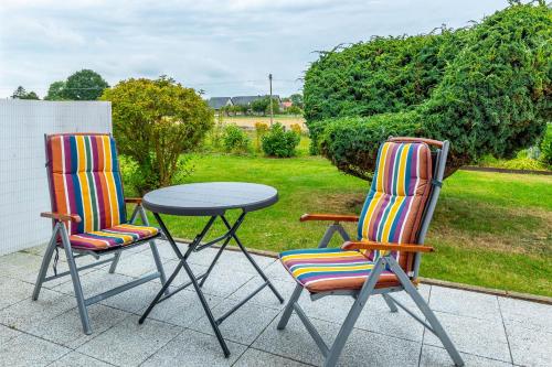 two chairs and a table on a patio at Ferienwohnung Tina EG in Boltenhagen