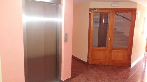 
a kitchen with a door open and a refrigerator at Hotel Orla in Vielha
