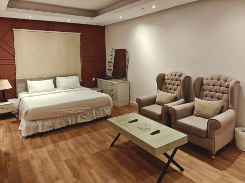 a bedroom with a bed and a couch and a table at NOVA Homes in Medina