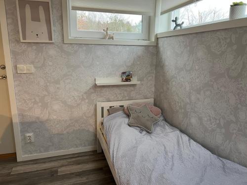 a childs bedroom with a small bed with a window at house with sea view in Varberg