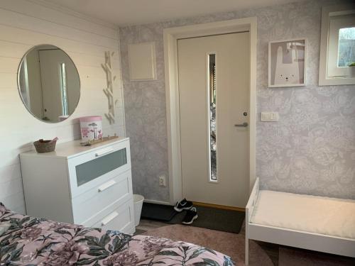 a bedroom with a bed and a mirror and a dresser at house with sea view in Varberg