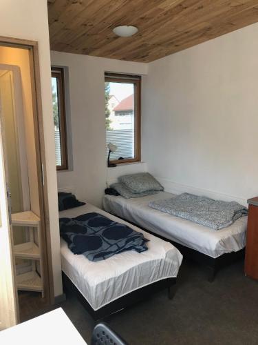 two beds in a room with two windows at Kwatery Mamma Mia Opawska 1a in Krzanowice