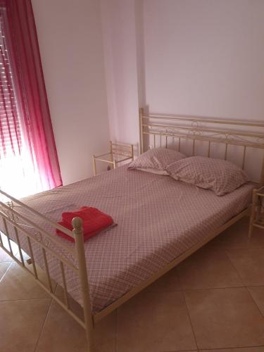 a bed in a bedroom with a red towel on it at Εξοχικό Σταμάτη in Lóngos