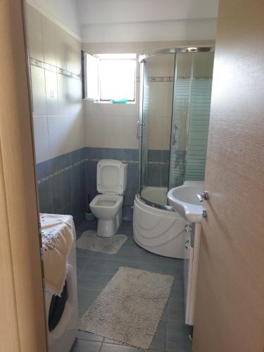 a bathroom with a toilet and a tub and a sink at Εξοχικό Σταμάτη in Lóngos